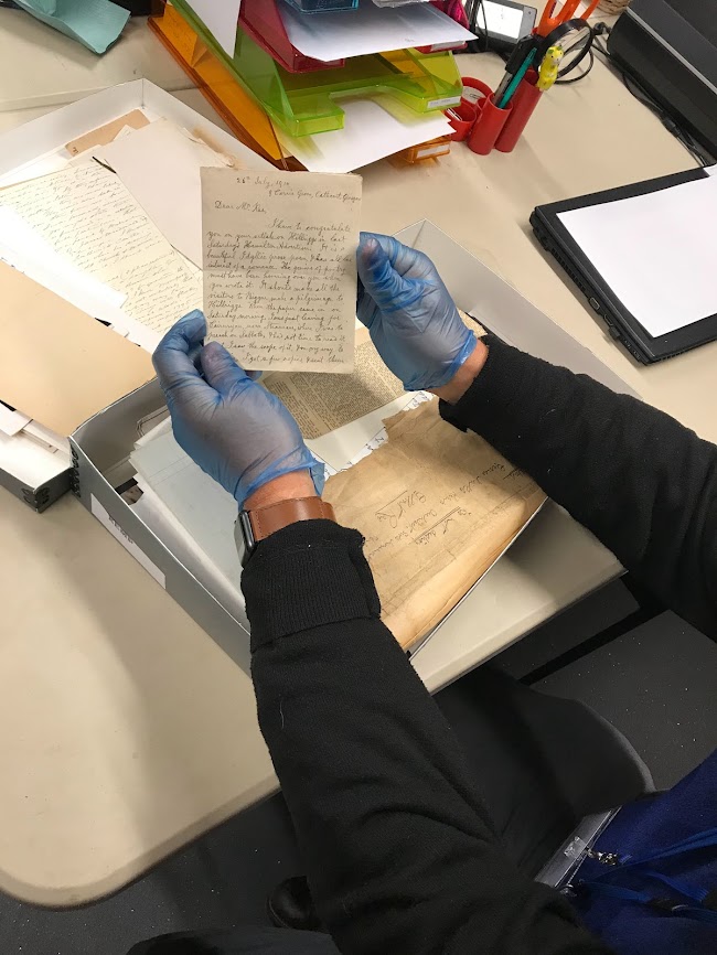 Archive Volunteer wearing blue gloves to collate historic documents